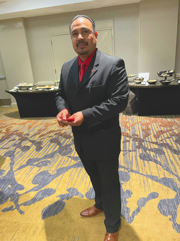 Roman Rocha in a black suit and red tie